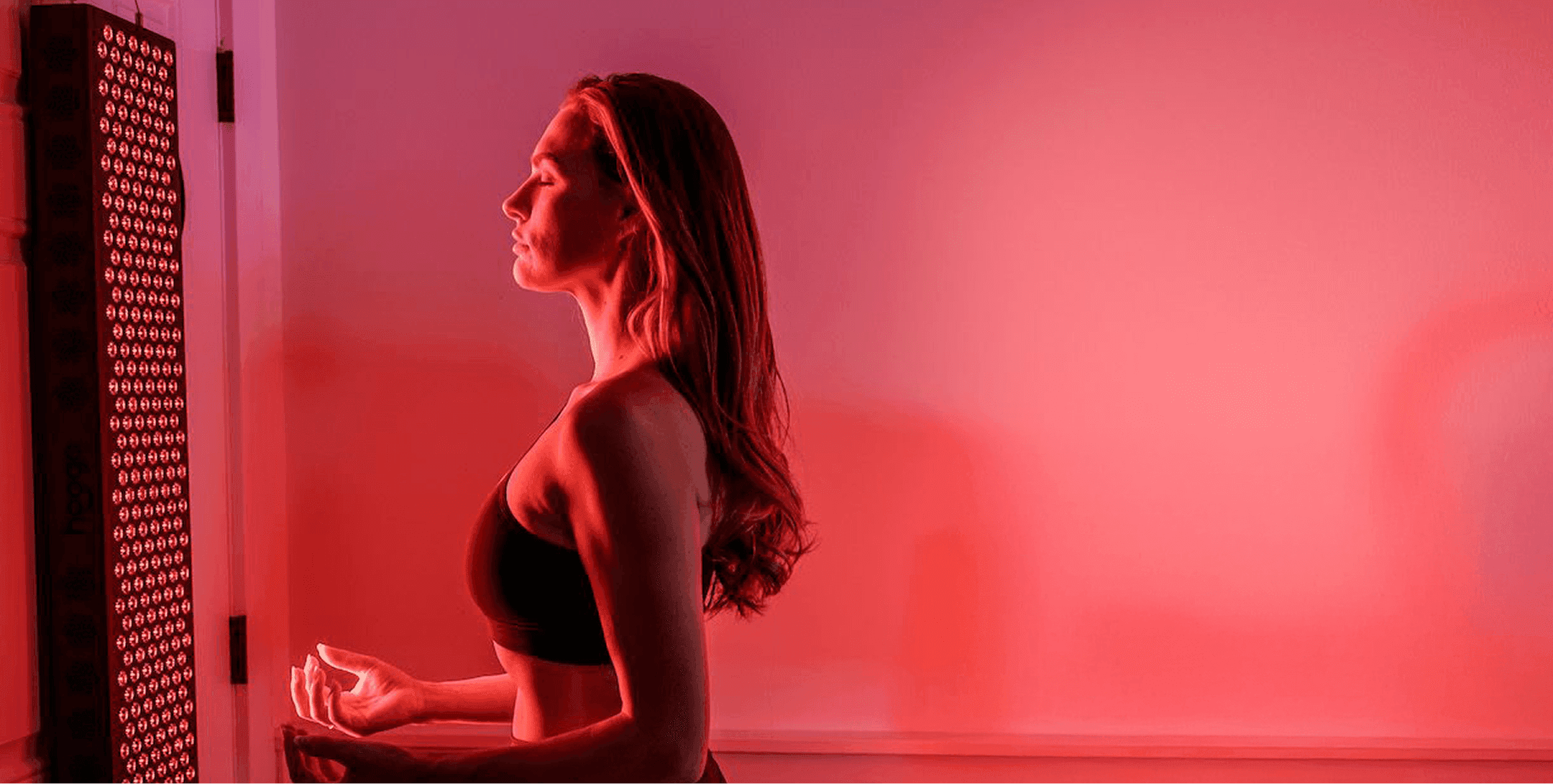 Woman bathed in red light during red light therapy